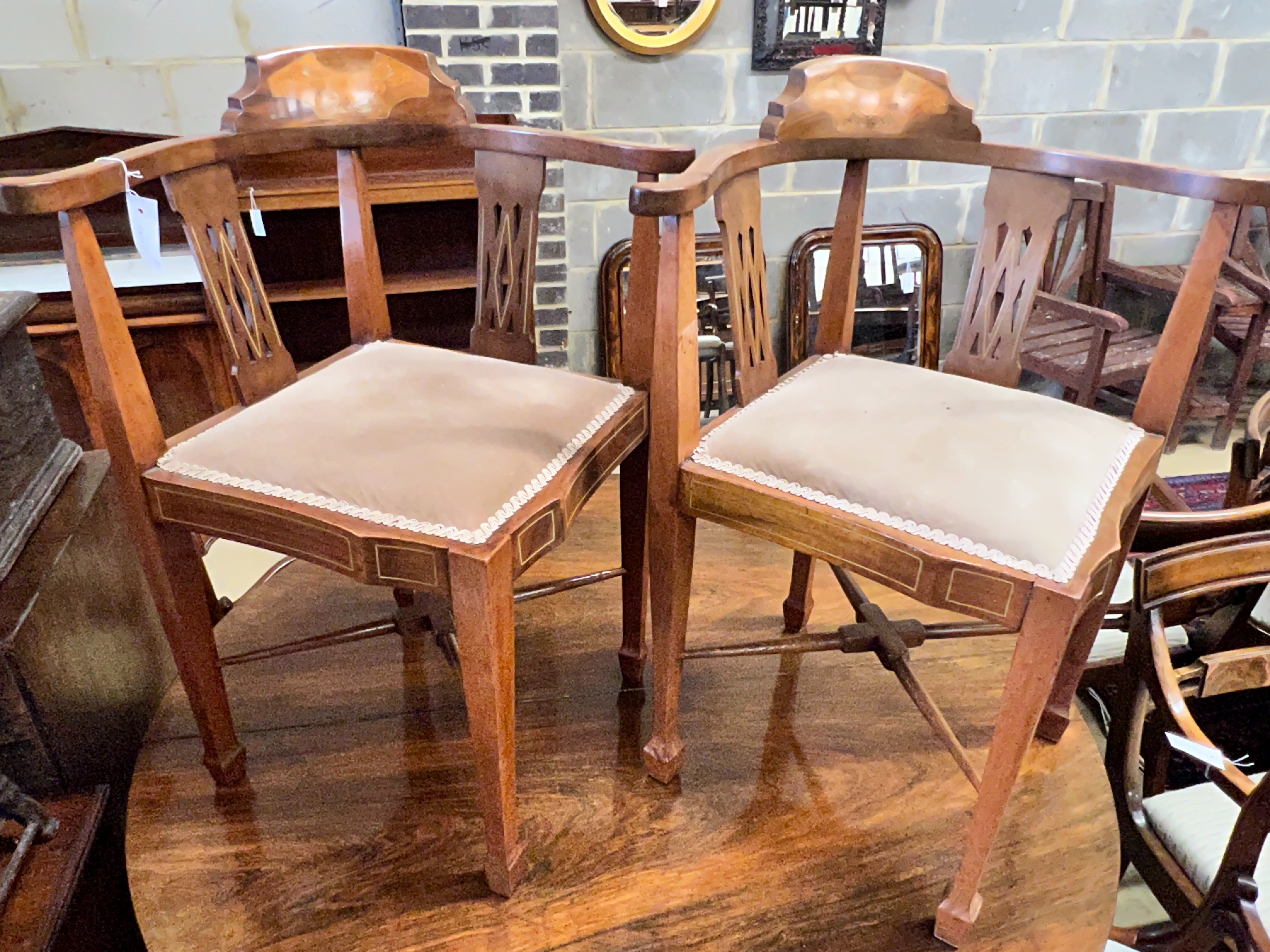A pair of Edwardian inlaid mahogany corner elbow chairs